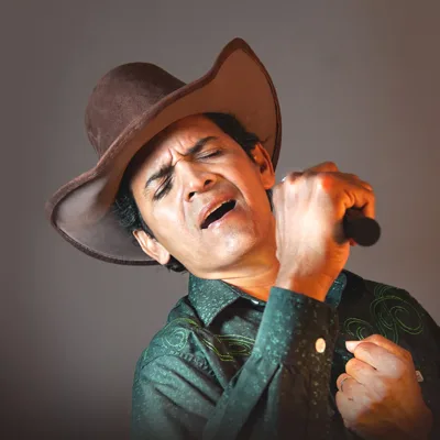 Naldin Trupela cantando de chapéu